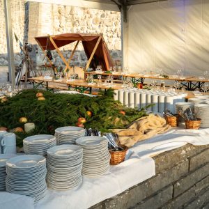 Buffébord med tallriksstaplar och grön mossdekor uppdukat mot slottsmuren